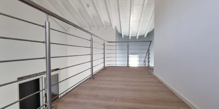 Scala a sbalzo con parapetto in acciaio inox satinato elicoidale e dritto. Tutte le parti dei tondini e corrimano sono saldati e satianti in opera.